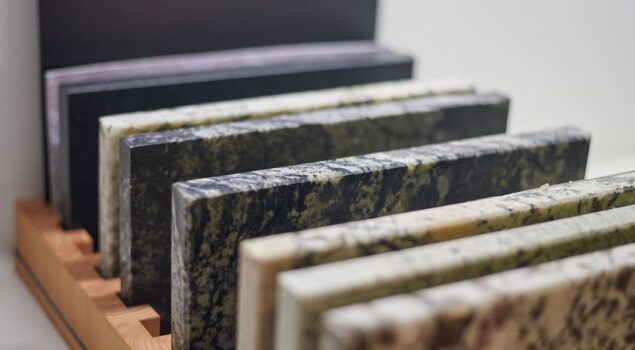 Amostras de mármore e granito em diferentes cores e texturas, organizadas em um expositor de madeira.