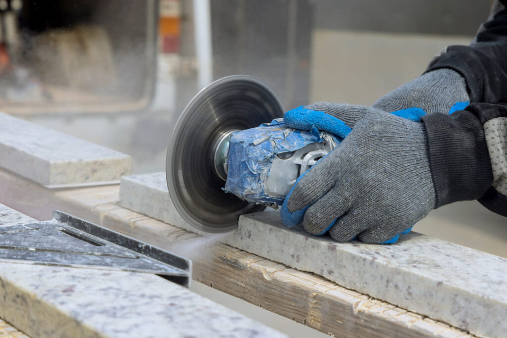 Profissional utilizando ferramenta el&eacute;trica com disco abrasivo para corte de pedra, demonstrando o uso e a import&acirc;ncia de armazenar abrasivos corretamente.