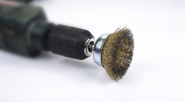 Ferramenta elétrica com uma das escovas de acabamento fosco acoplada, usada para polimento e remoção de impurezas em superfícies metálicas.