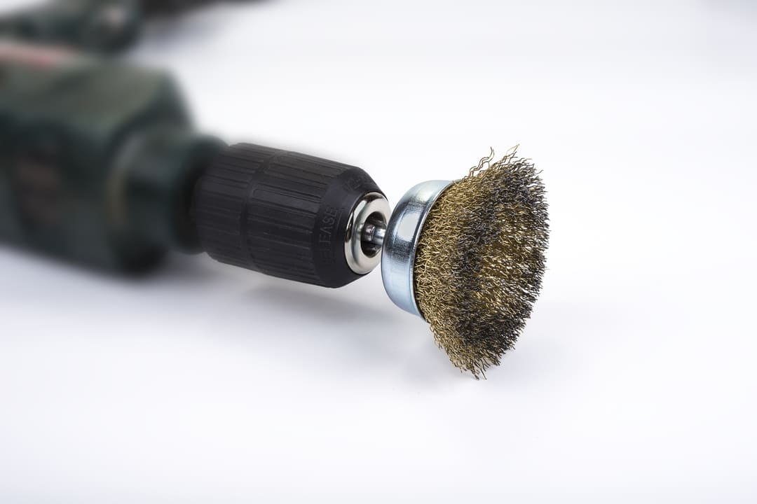 Ferramenta elétrica com uma das escovas de acabamento fosco acoplada, usada para polimento e remoção de impurezas em superfícies metálicas.