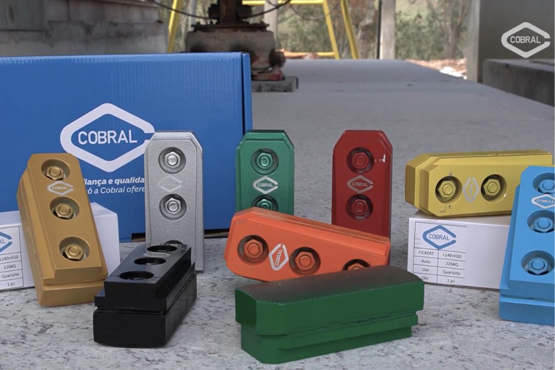 Linha de abrasivos Cobral em diferentes cores e formatos dispostos sobre uma superfície, com caixa da marca ao fundo, representando opções para polimento de pedras naturais.
