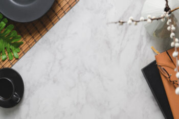 Superfície de pedra sintética clara com acabamento uniforme, vista de cima, utilizada como bancada em ambiente corporativo ou comercial.